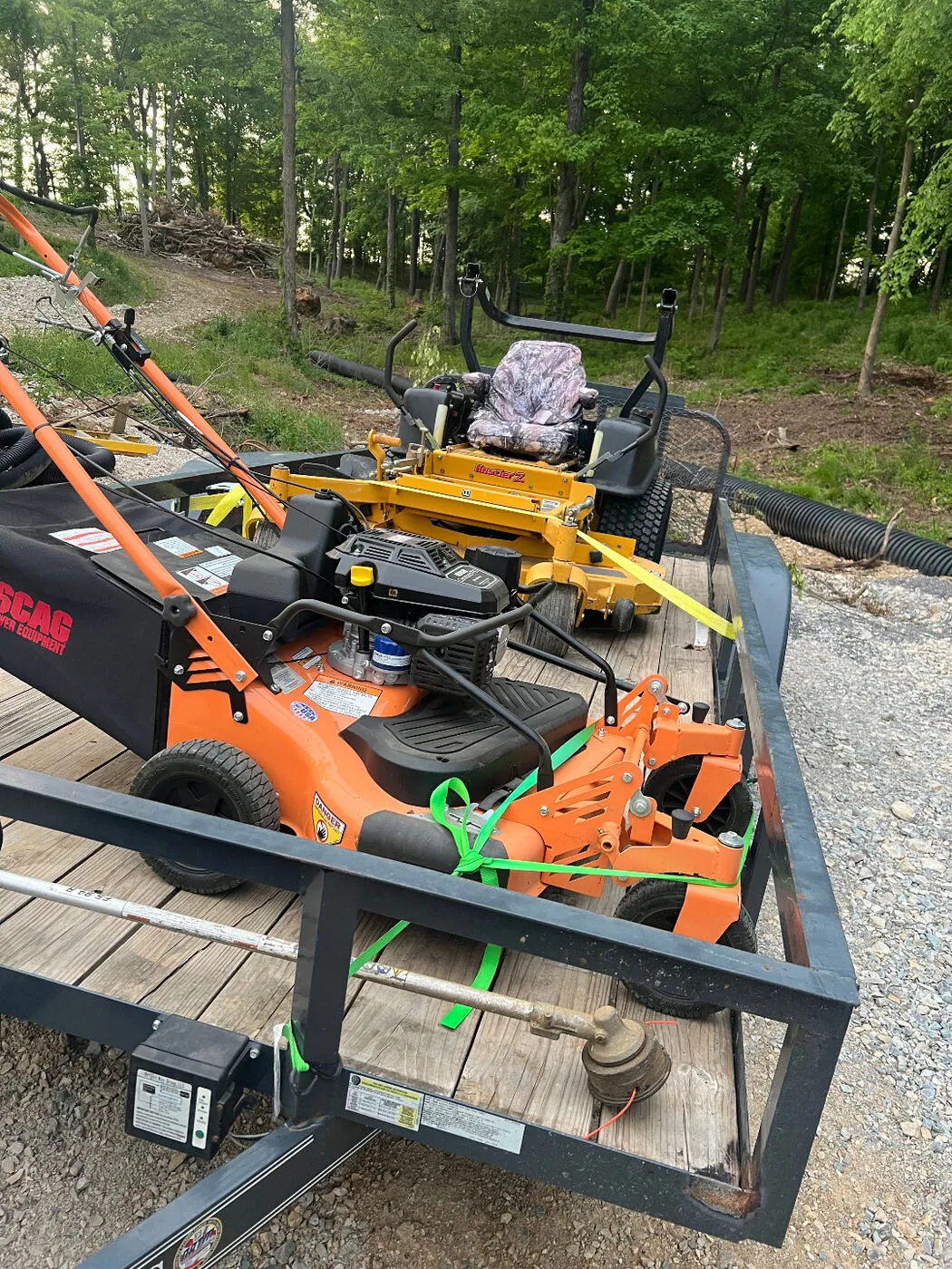 Trailer loaded with a Scag walk-behind mower and a Husqvarna zero-turn ready for the next job.